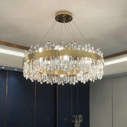 A modern circular gold decorbites crystal chandelier with cascading clear prisms for living room lighting