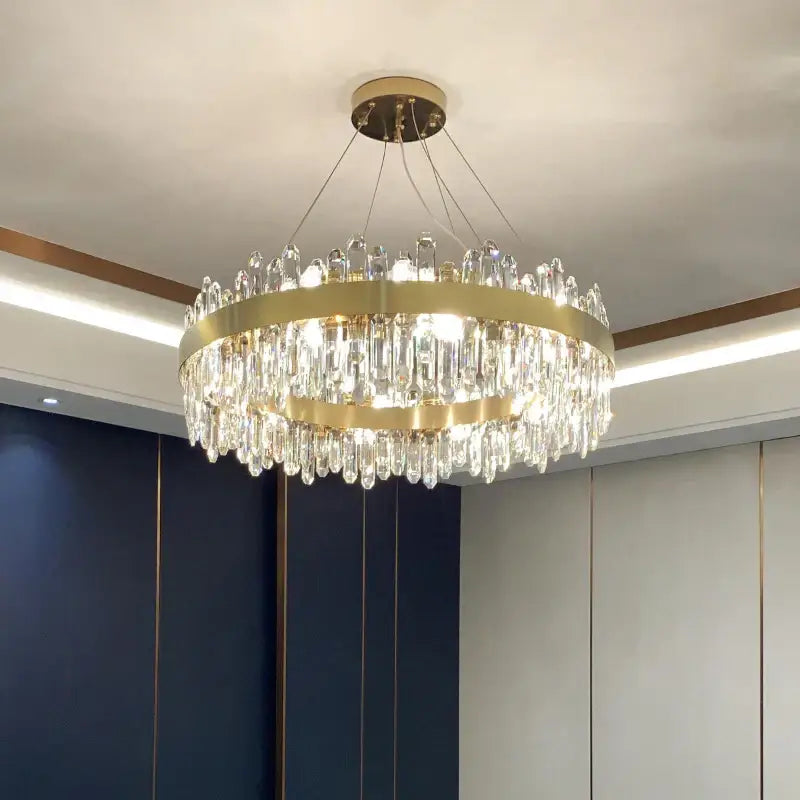 A modern circular gold decorbites crystal chandelier with cascading clear prisms for living room decor