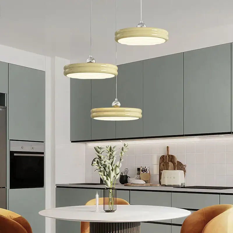 Three pale yellow circular modern chandelier pendant lights with glossy finish hanging in dining room decorbites circular modern