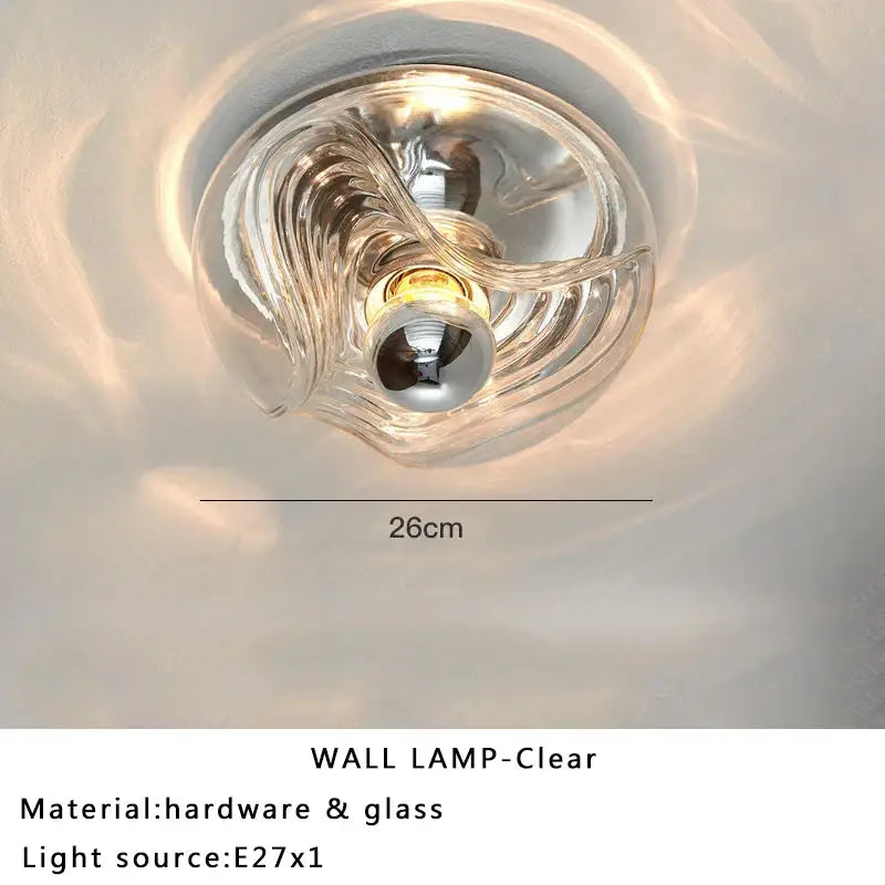 Modern circular swirling designer glass wall lamp with clear transparent glass and metallic hardware for bedroom decorbites designer glass wall