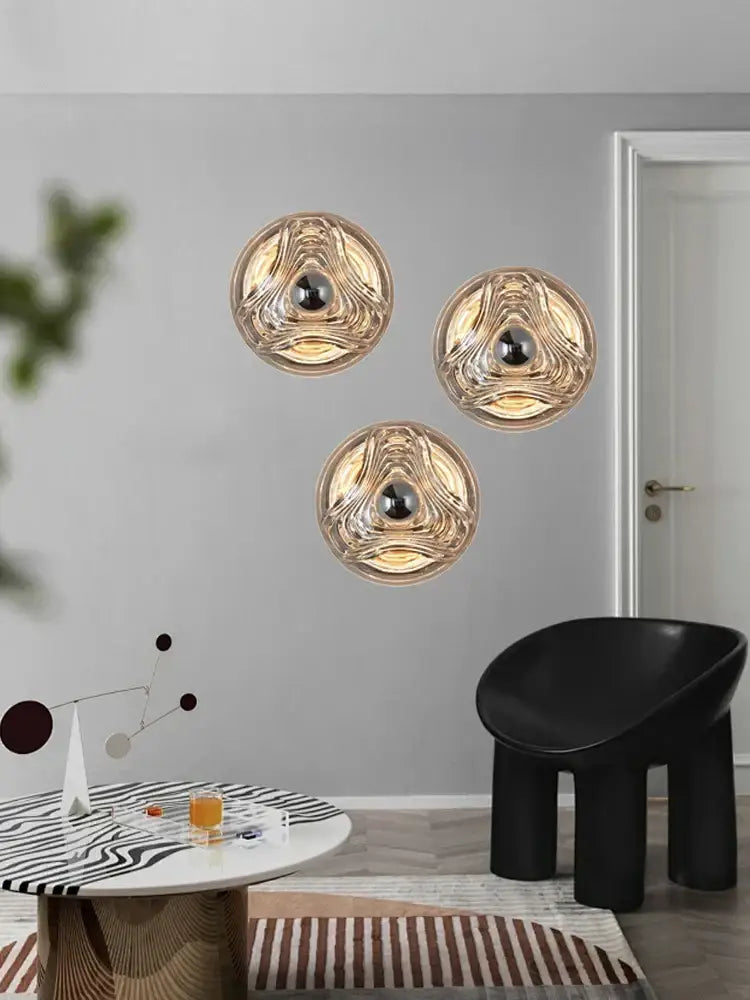 Three gold-toned translucent glass pendant wall lamps with swirling design decorbites designer glass wall lamp for bedroom