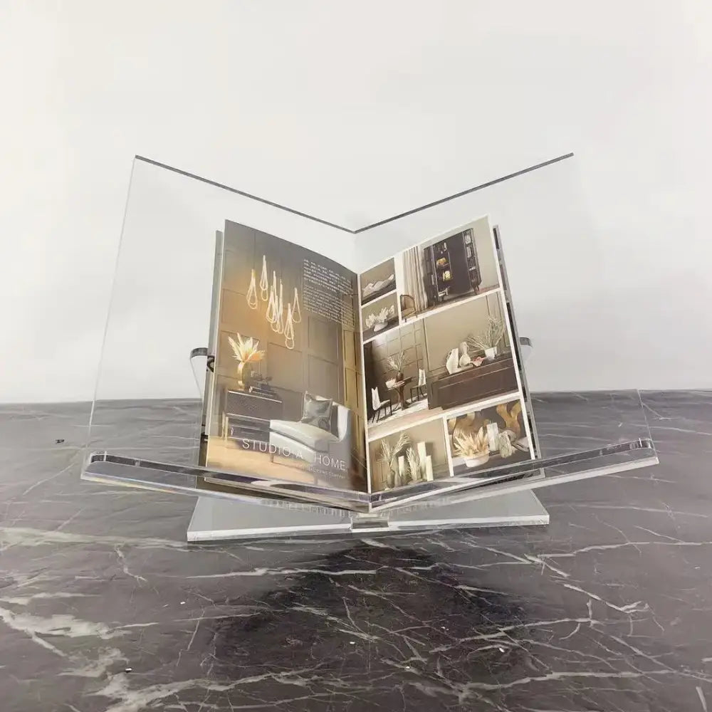 Modern clear acrylic geometric magazine rack holding an open interior design magazine on an office desktop storage solution