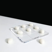 Modern clear acrylic tic tac toe board with white textured resin pebble chess pieces for living room decor