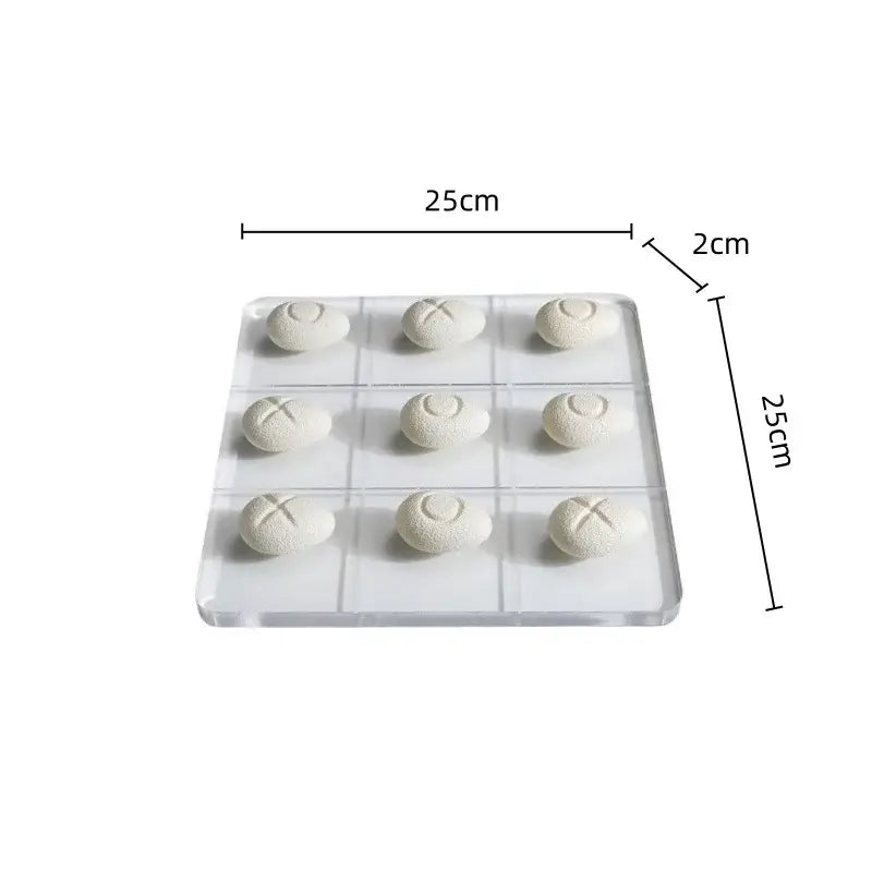 Modern clear acrylic tic tac toe board with white resin pebble chess pieces featuring engraved o and x marks for living room decor
