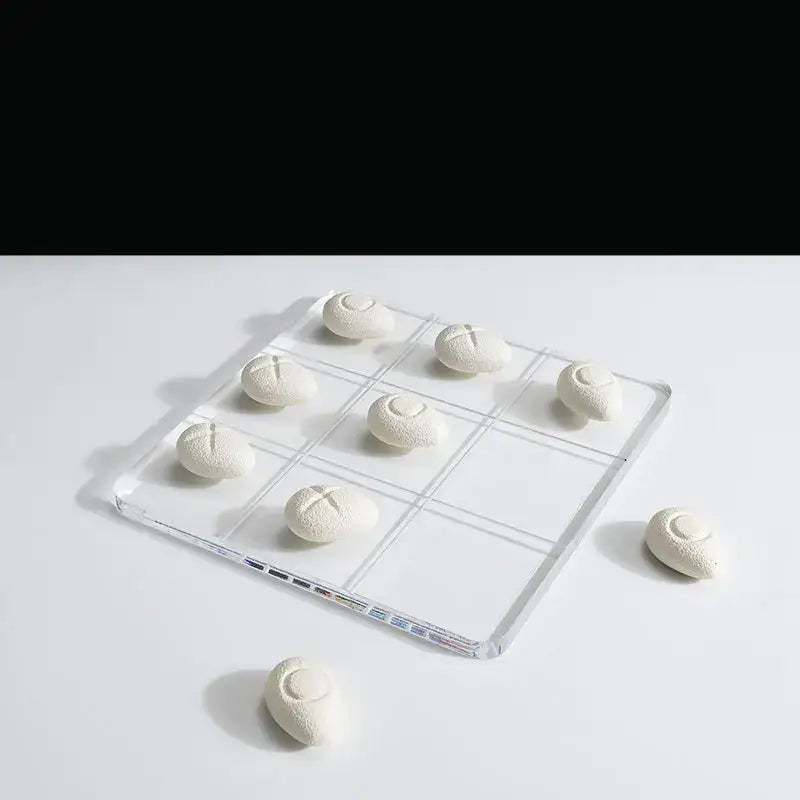 Modern clear acrylic tic tac toe board with white textured resin pebble chess pieces for living room decor