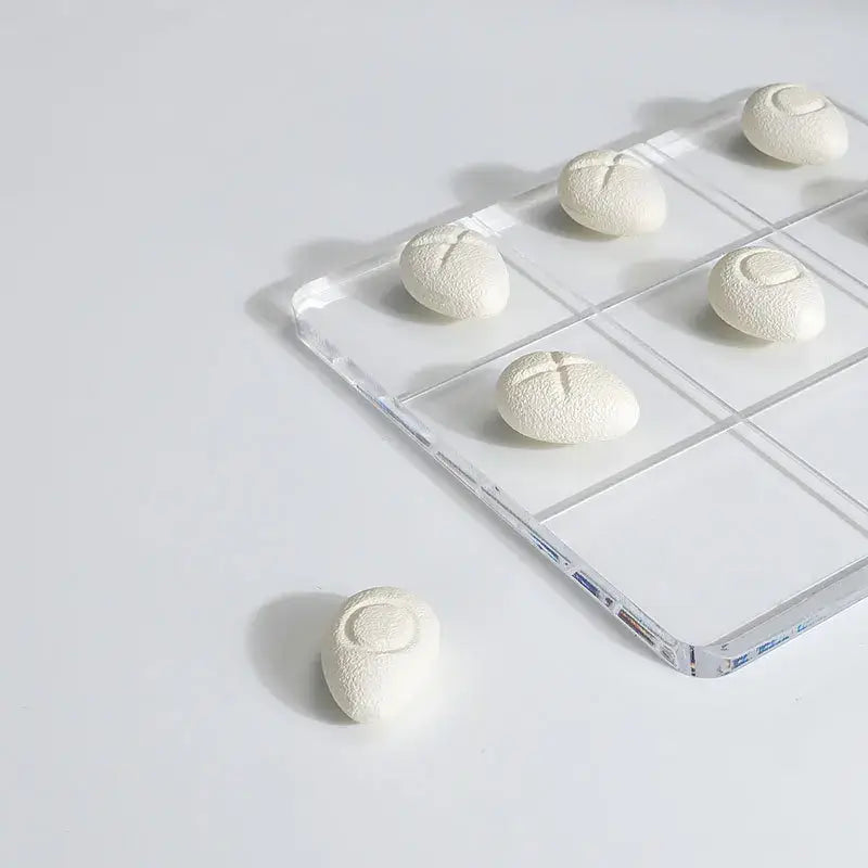 Modern clear acrylic tic tac toe board with white textured resin pebble chess pieces for living room decor