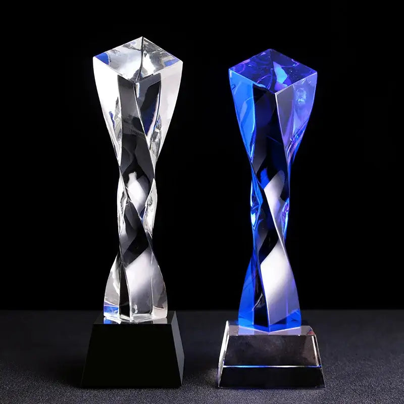 Two crystal award trophies featuring a modern clear and blue glass twisted column with faceted surfaces decorbites blue glass