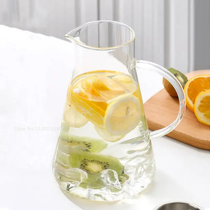 Modern clear borosilicate glass pitcher with stainless steel lid filled with ice lemon slices and kiwi rounds