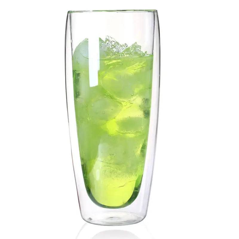Tall modern clear double wall glass cup filled with vibrant green beverage and ice cubes for dining room use