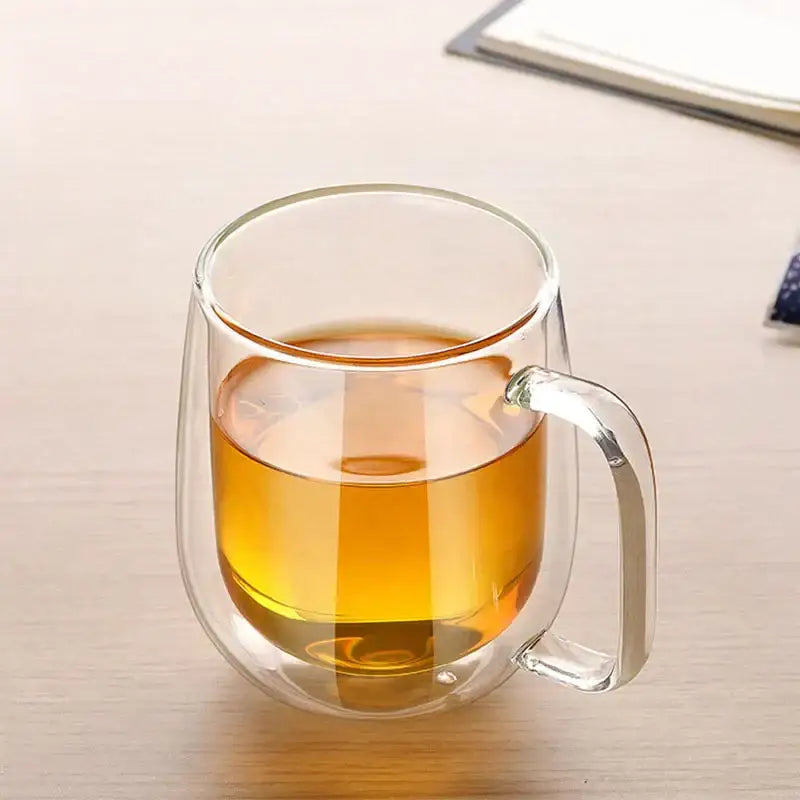 Modern clear double wall glass mug filled with amber tea showcasing the double wall glass design for kitchen use