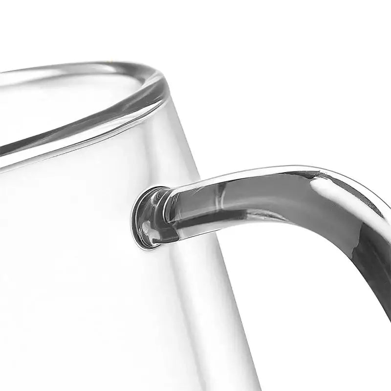 Modern clear double wall glass mug with a sleek curved metallic handle for kitchen and tea use