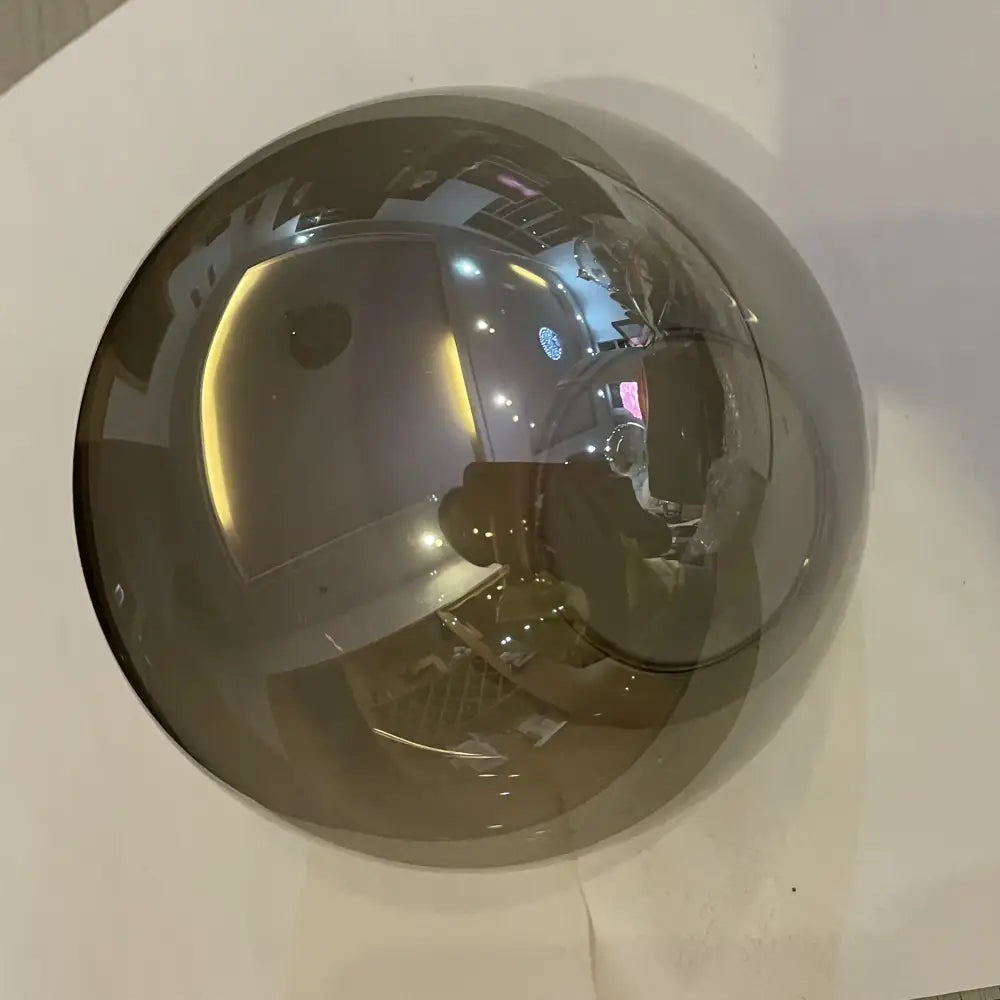 A sleek chrome decorbites glass ball pendant light with a reflective polished surface for dining room decor