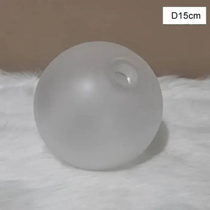 A frosted glass shade cover replacement with a smooth opaque surface and circular opening for living room use