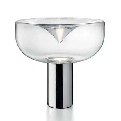 Modern clear glass aella table lamp with sleek chrome base and triangular cutout for bedroom or office decorbites aella