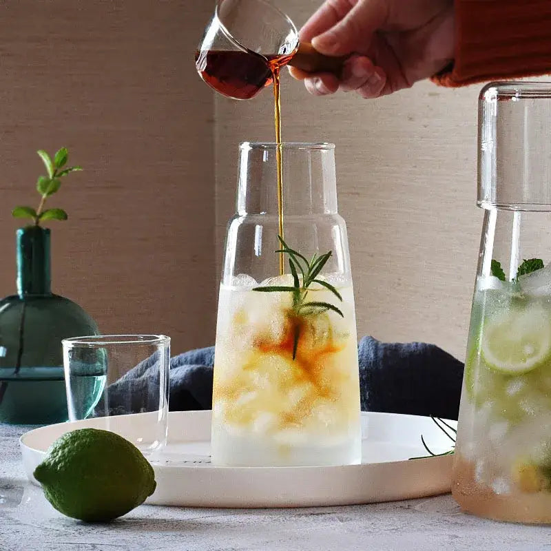 Modern clear glass bedside water carafe set with clear glass pitcher filled with ice lemon and rosemary for decorbites clear glass