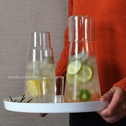 Modern clear glass bedside carafe set with matching lid filled with ice and sliced citrus for glass bedside water use