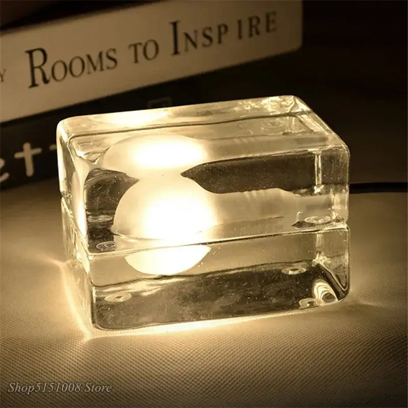 Modern clear glass cube led table lamp with warm glowing bulb ideal as a bedroom nightlight and led table lamp