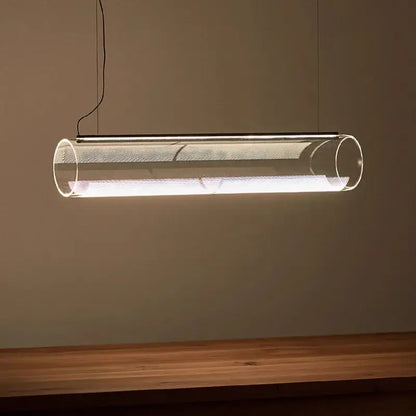 Modern clear glass cylinder chandelier pendant light with metallic mesh interior emitting warm white illumination