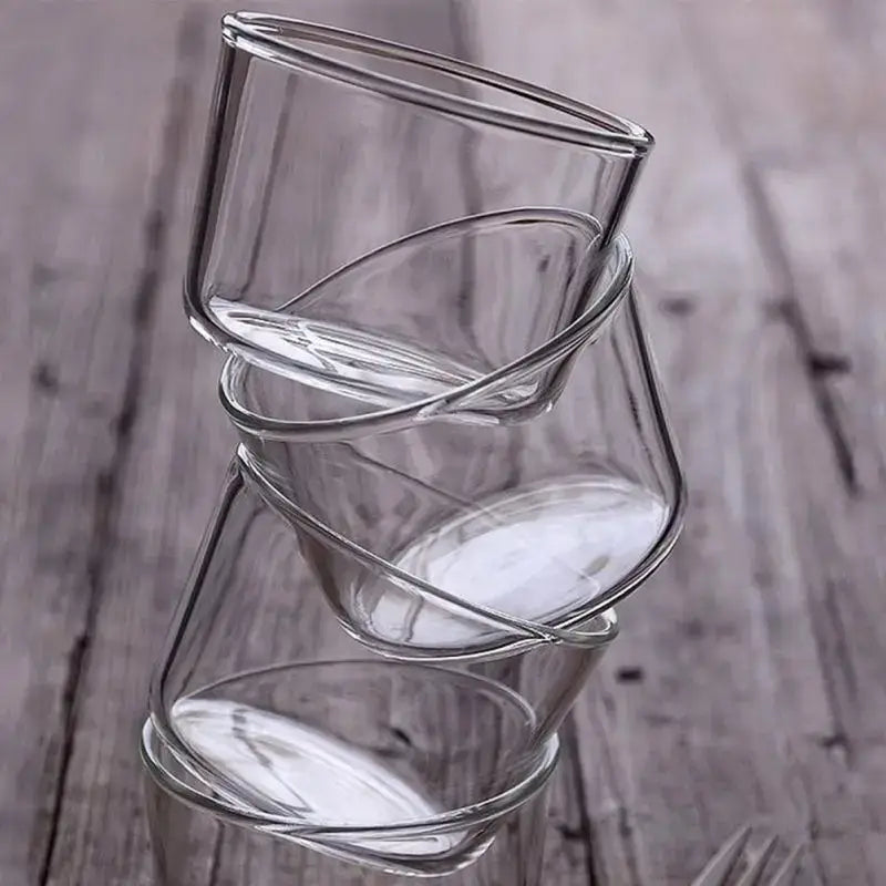 Modern clear glass dessert cup set with twisted design stacked in an overlapping arrangement for dining use