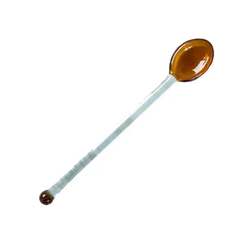 A translucent amber glass spoon with a clear handle complements the modern clear glass dessert cup set