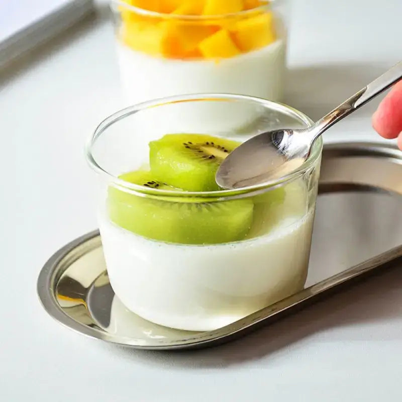 Modern clear glass dessert cup set featuring a transparent glass dessert cup with white pudding and kiwi topping