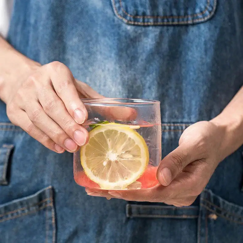 Modern clear glass drinkware cup set featuring a clear glass drinkware cup with pink liquid and a lemon slice
