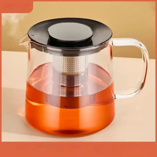 Modern clear glass flower teapot with stainless steel infuser and black lid filled with amber tea for kitchen use