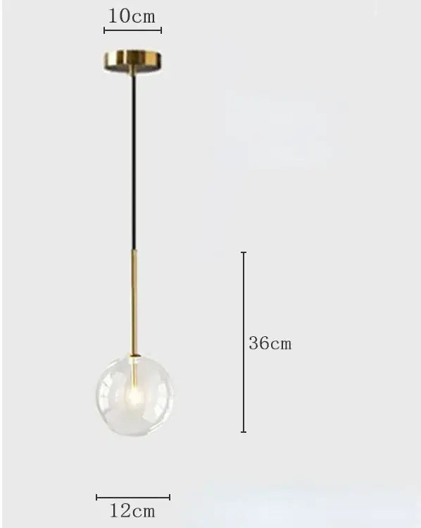Modern pendant light with a clear transparent glass globe and gold brass rod suspension for kitchen lighting