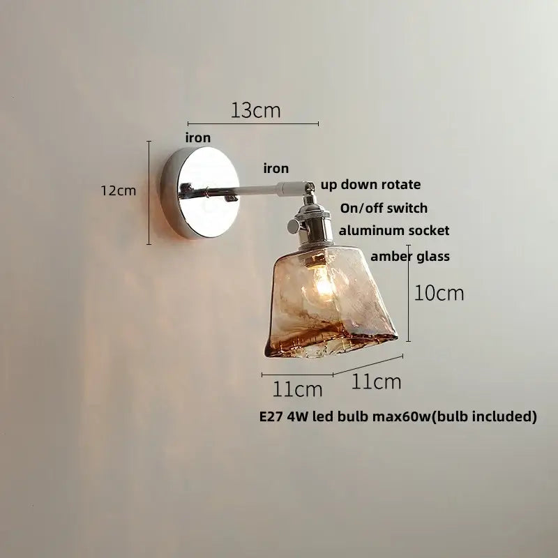 A sleek modern clear glass wall lamp with a polished iron base and amber shade for bedroom decorbites clear glass lighting