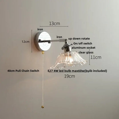 A sleek modern wall lamp with a polished iron base and clear glass shade for bedroom decorbites clear glass lighting