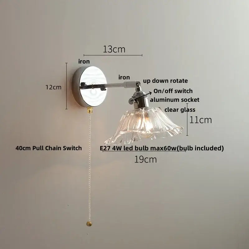 A sleek modern wall lamp with a polished iron base and clear glass shade for bedroom decorbites clear glass lighting