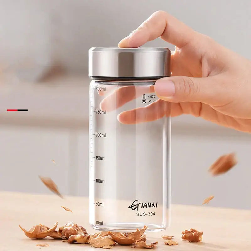 Modern clear glass sealed jug with stainless steel lid and black measurement markings for kitchen storage and measuring