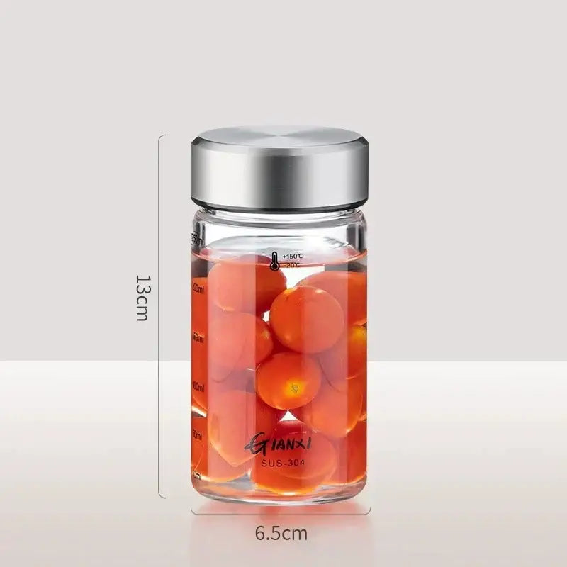 Modern clear glass sealed jug kitchen storage jar with stainless lid filled with cherry tomatoes and measurement lines