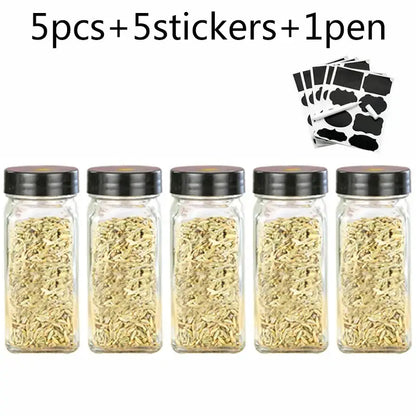 Modern clear glass seasoning jar set with five glass seasoning jars filled with fennel seeds and black lids for kitchen use