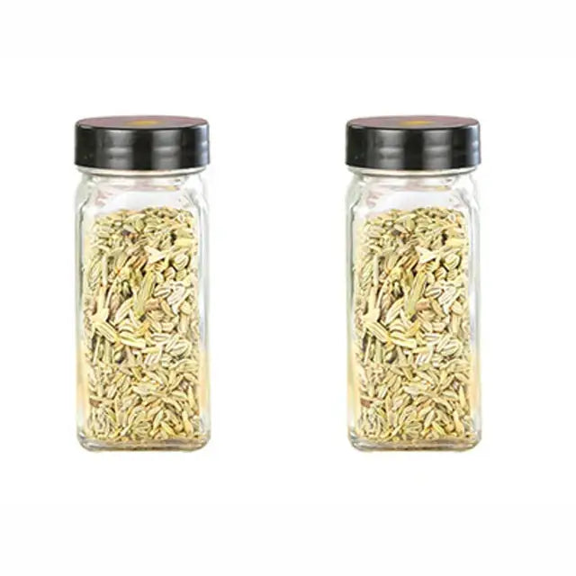 Modern clear glass seasoning jar set with black lids featuring two glass seasoning jars filled with fennel seeds
