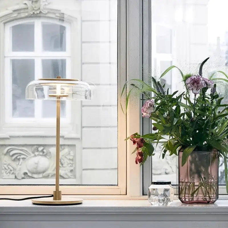 A modern clear glass table lamp with a transparent dome and brass base for bedroom candle style desk light decorbites clear glass