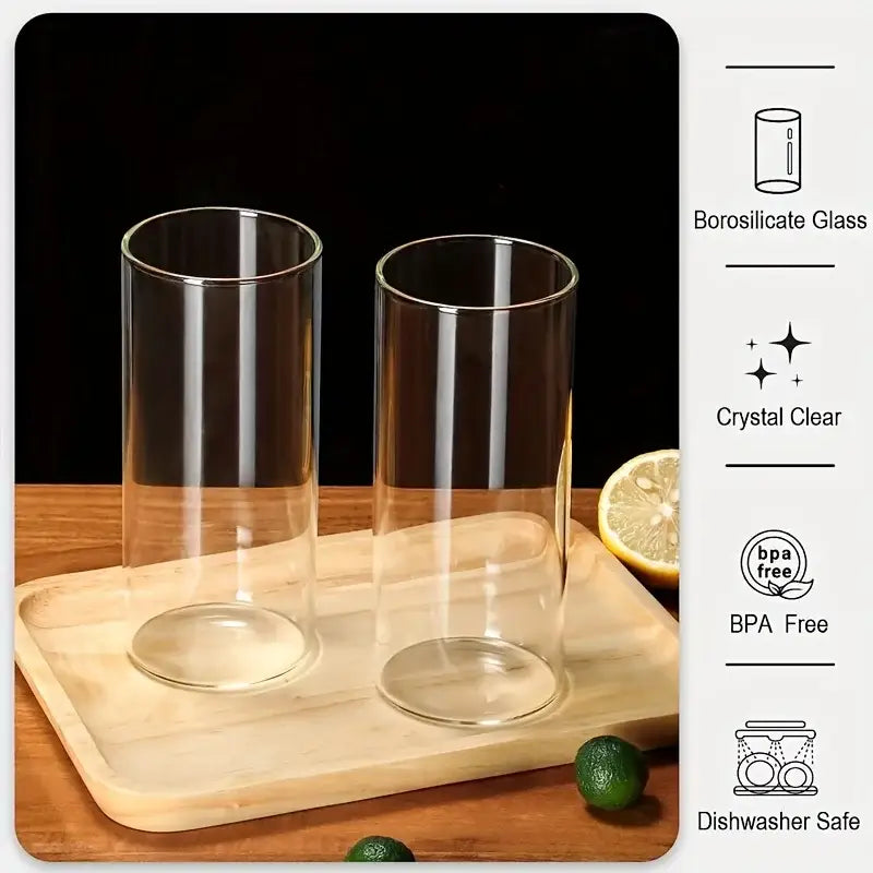 Two clear borosilicate glass tumbler cups with sleek cylindrical design and rounded bases from a modern 4-piece bamboo lid set