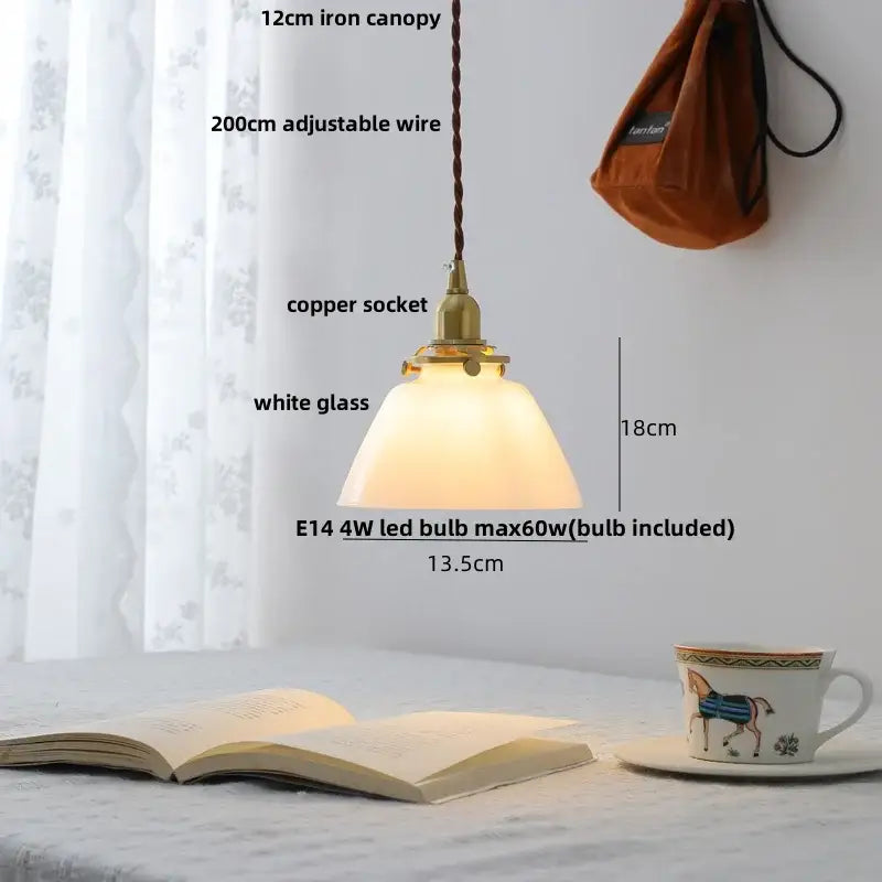 A warm glowing led pendant lamp with white glass shade and brass copper socket for modern kitchen lighting