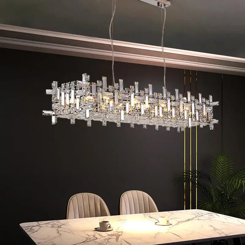 Modern clear and gold elegant crystal chandelier with clear crystal prisms and led lights above marble dining table decorbites elegant crystal