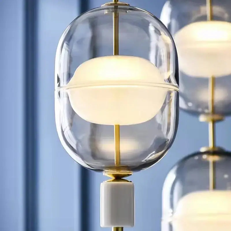 Modern clear gray amber glass pendant light with rounded globe and warm white frosted inner bulb for dining room decorbites clear gray
