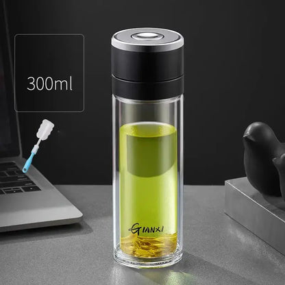 Modern clear insulated glass cup filled with green tea featuring decorbites insulated glass and black silver lid