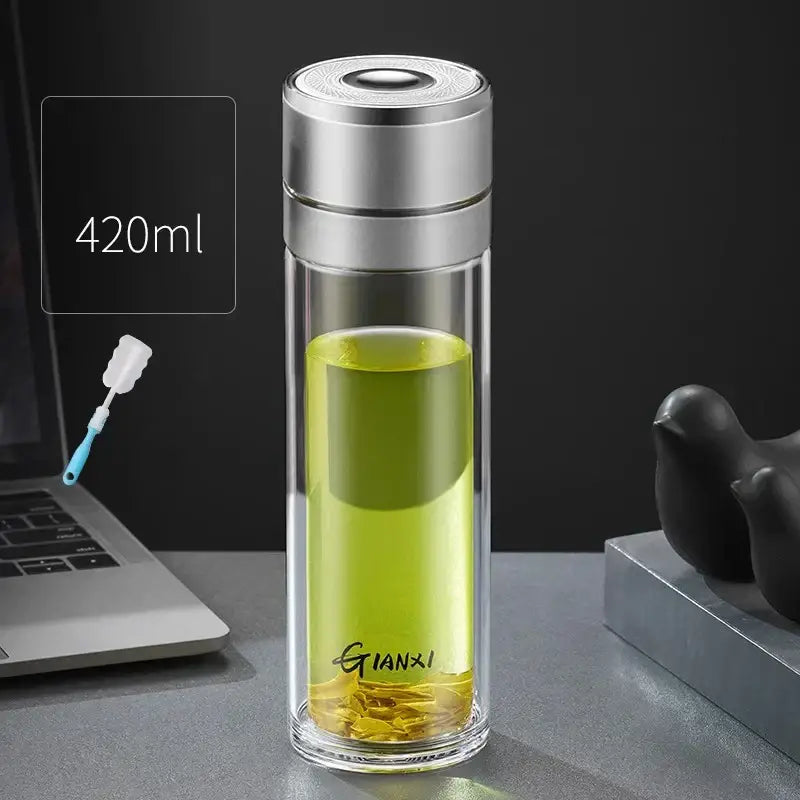 A sleek 420ml modern clear decorbites insulated glass cup with silver lid filled with green tea and gianxi branding