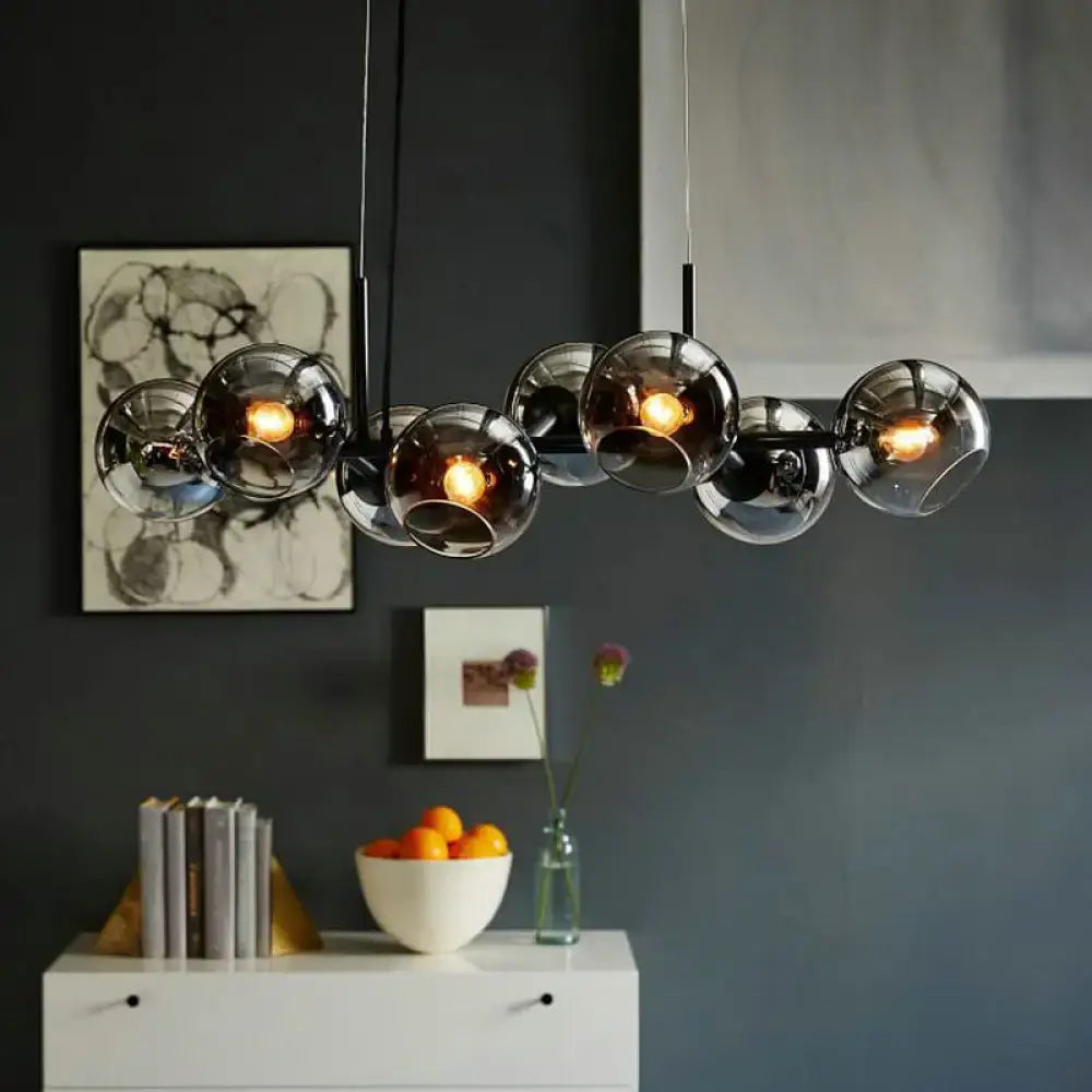 Modern clear smoke glass lighting fixture with black metal frame and warm-toned bulbs for dining room use