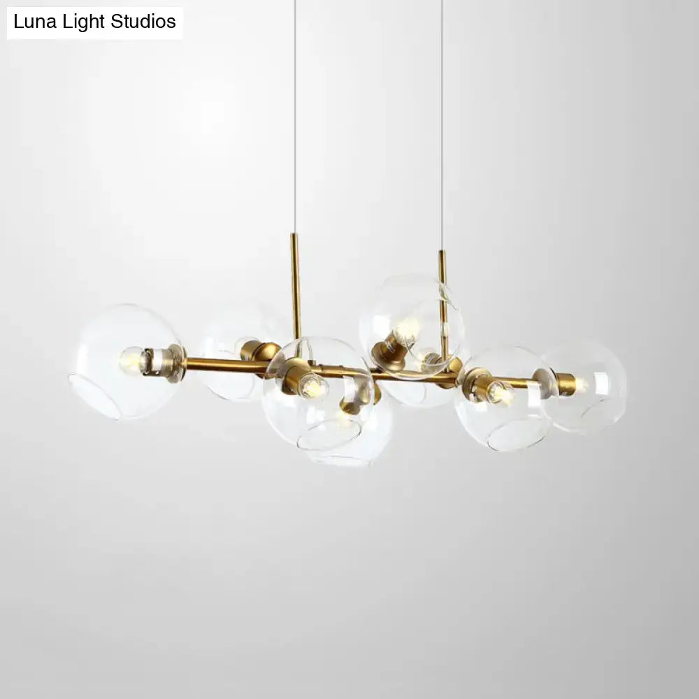 Modern clear smoke glass lighting fixture with brass and black accents featuring eight spherical bulbs for dining room