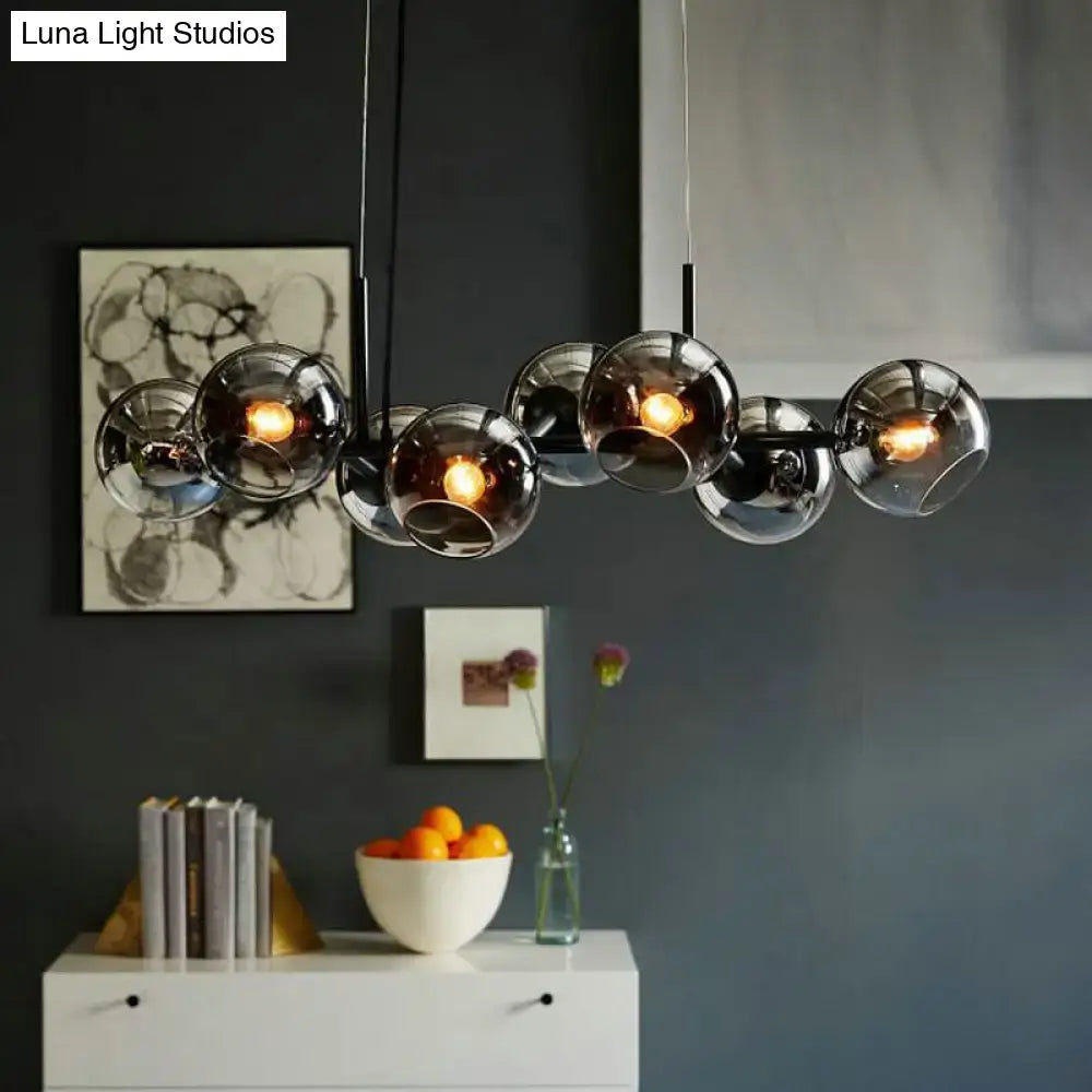 Modern clear smoke glass lighting fixture with eight warm bulbs and sleek black metal frame for dining room use