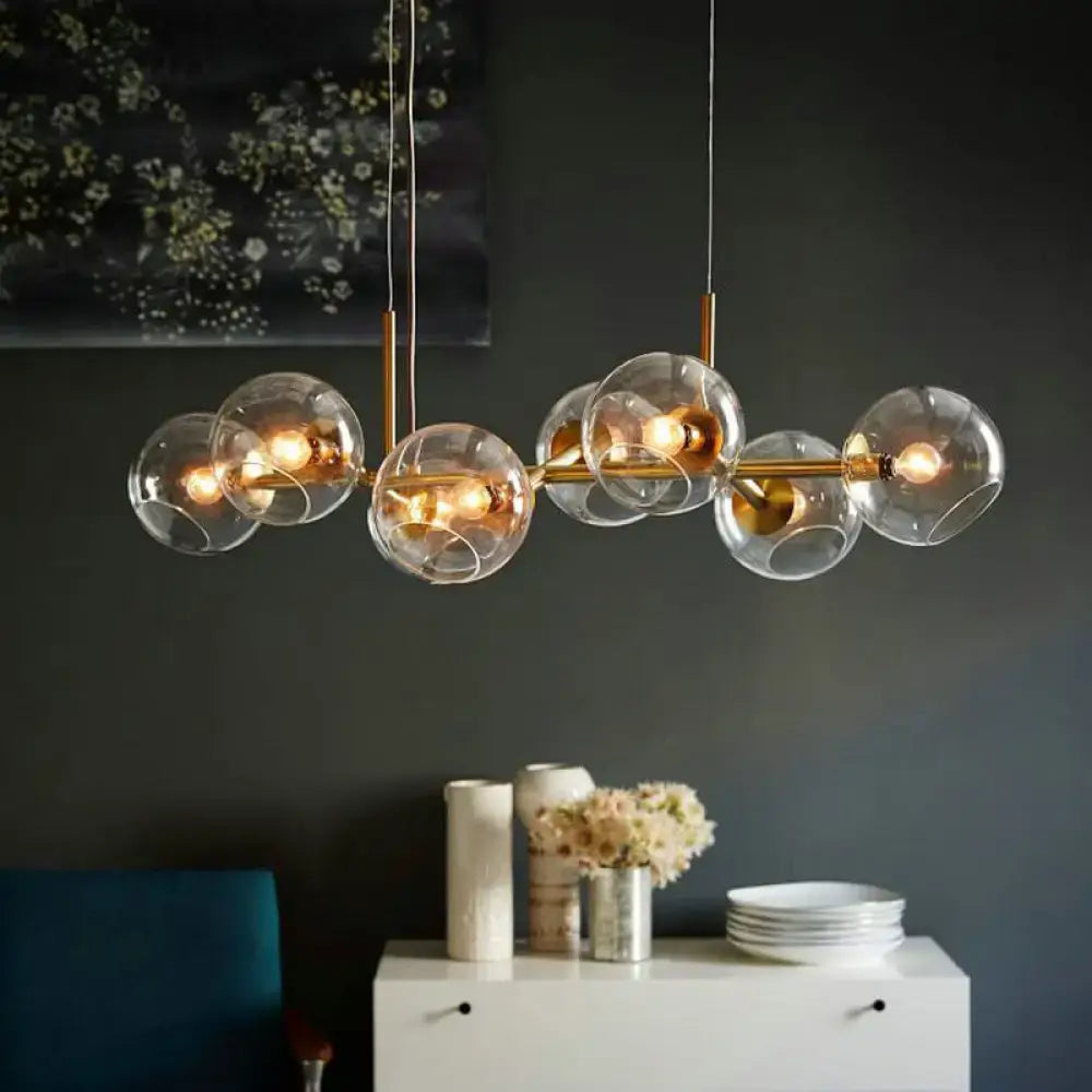 Modern brass chandelier lighting fixture with clear smoke glass globe shades in black and gold for dining room use