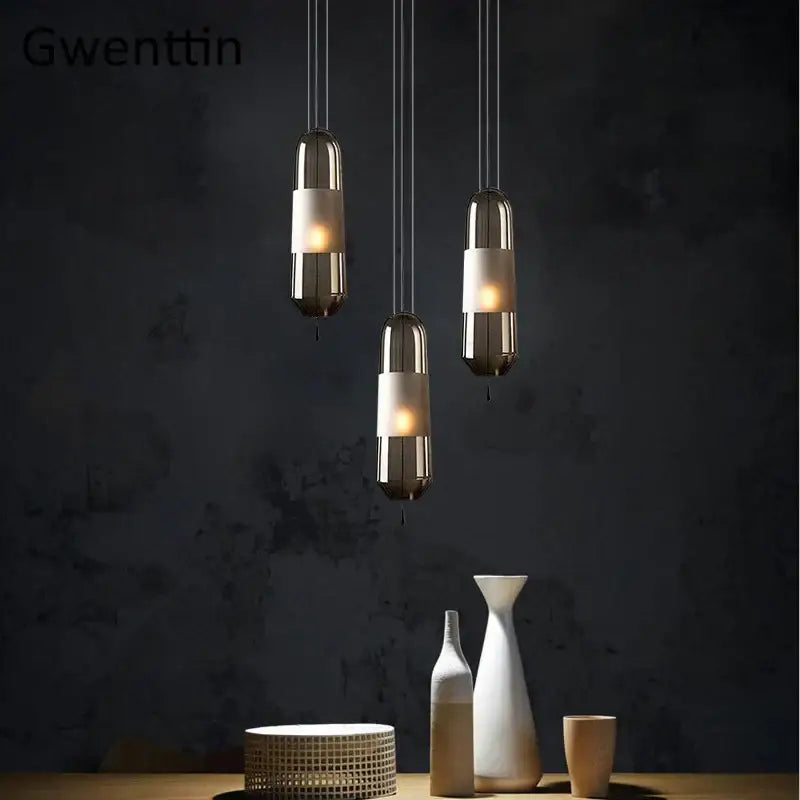 Modern clear and smoked glass pendant lights with sleek metallic shades and warm glow for dining room use