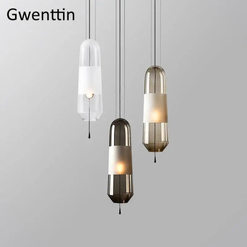 Modern clear and smoked glass pendant lights with sleek cylindrical shades and metallic bands for dining room use
