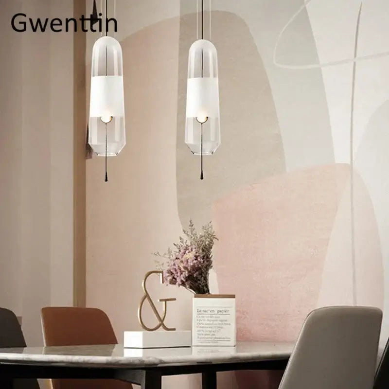 Two modern pendant lights with clear glass shades and white inner panels for dining room use
