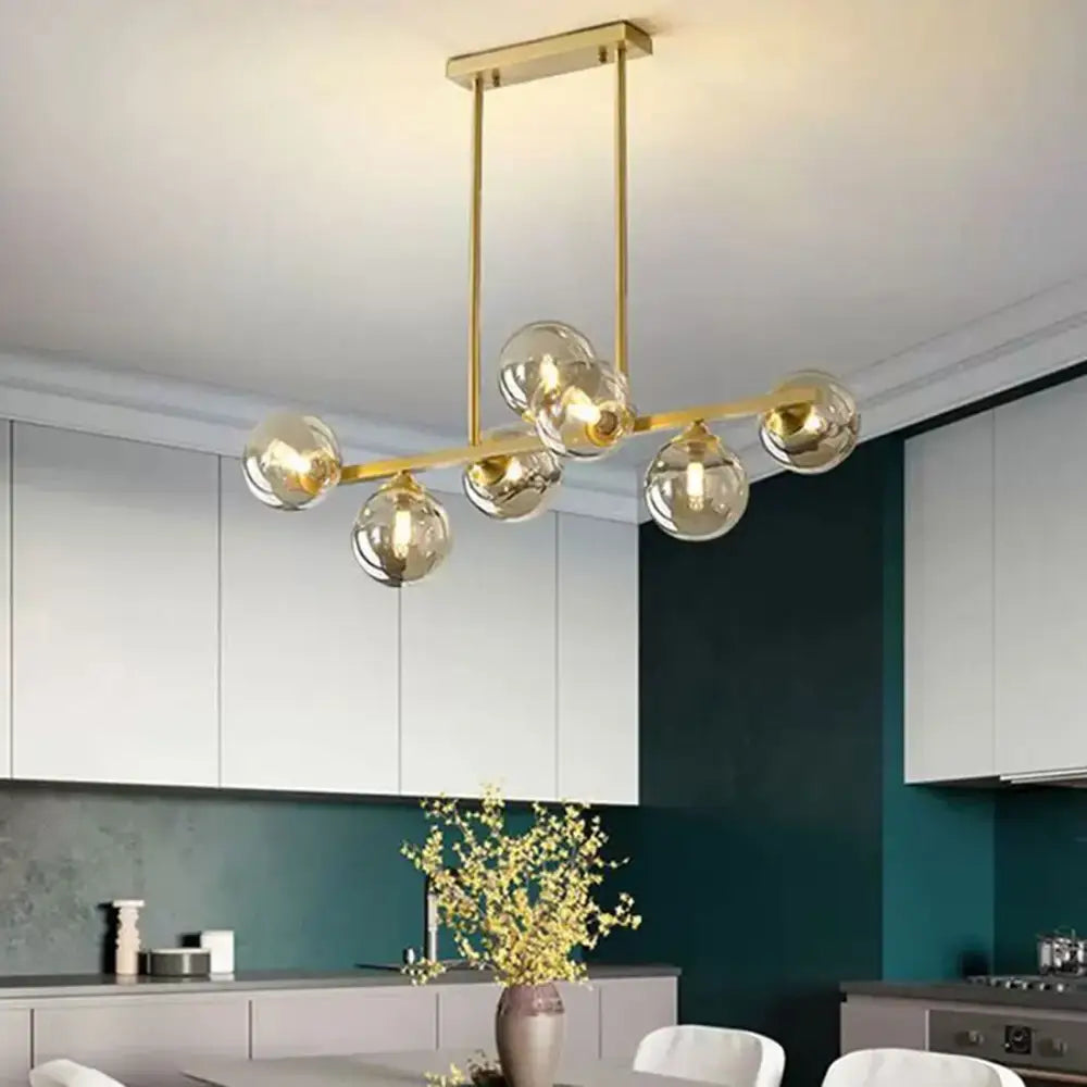 Gold-toned modern chandelier with spherical clear and smoked glass shade replacement for living room use
